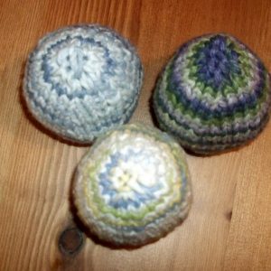 Three hand-knitted easter eggs made with self-striping yarn.